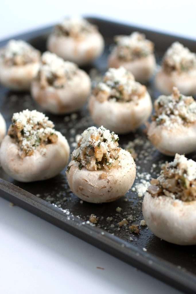 Prepped stuffed mushrooms on a baking sheet