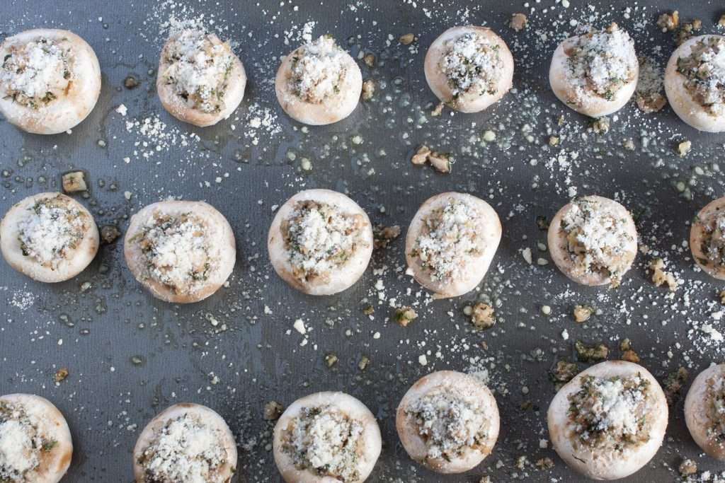 Prepped stuffed mushrooms on a baking sheet